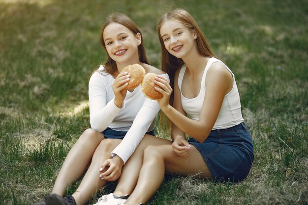 Duas meninas elegantes e com estilo em um parque primavera