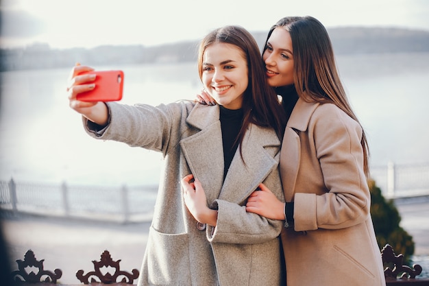 Duas meninas elegantes têm um descanso em uma cidade