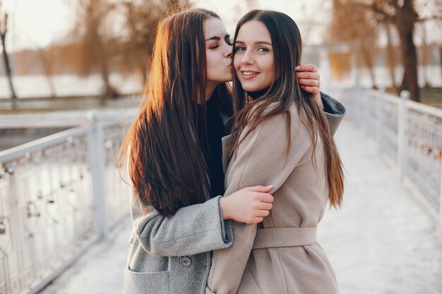 Duas meninas elegantes têm um descanso em uma cidade