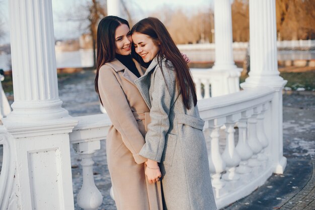 Duas meninas elegantes têm um descanso em uma cidade