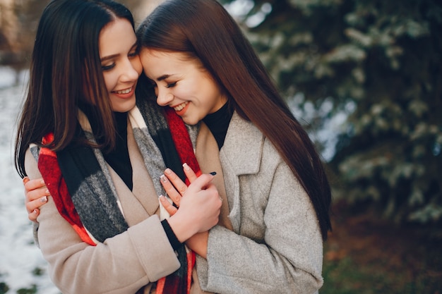 Duas meninas elegantes têm um descanso em uma cidade