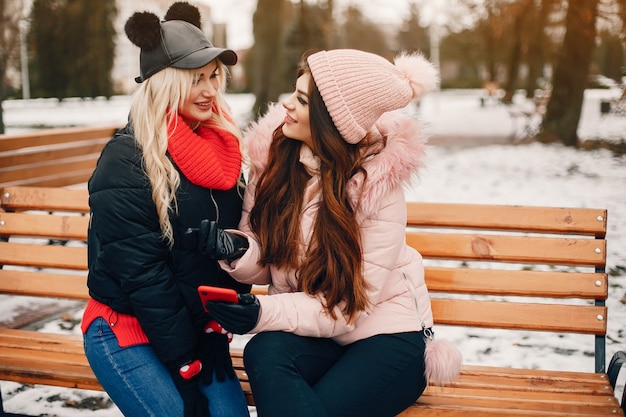 Duas meninas elegantes têm um descanso em uma cidade