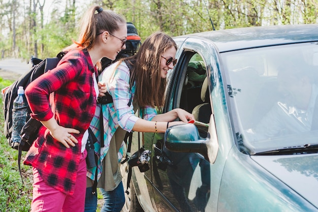 Foto grátis duas meninas inclinadas para a janela do carro