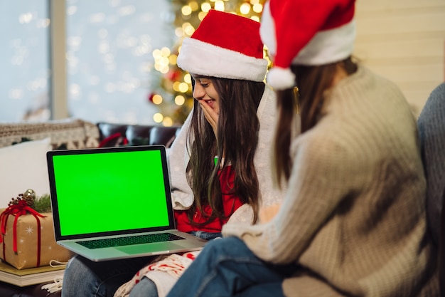 Duas meninas se comunicam pela Internet com amigos.