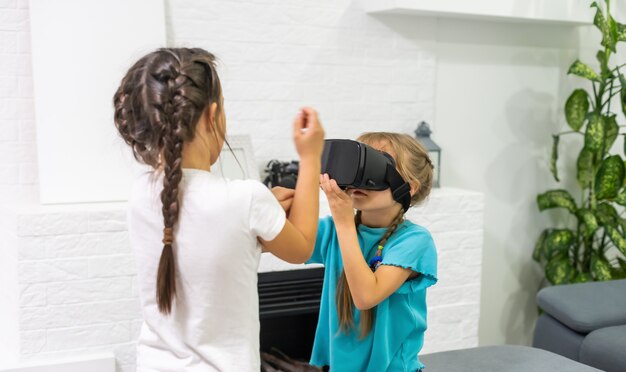 Duas meninas usando óculos de fone de ouvido de realidade virtual. conceito de tecnologias modernas