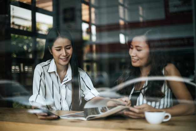 Duas mulheres bonitas falando tudo juntos no café café