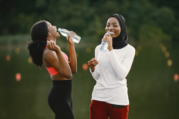Duas mulheres conversando perto do lago depois de fazer algum treino