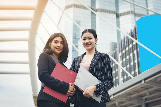 Duas mulheres de negócios de pé e discutindo na frente do escritório. Conceito de trabalho empresarial.