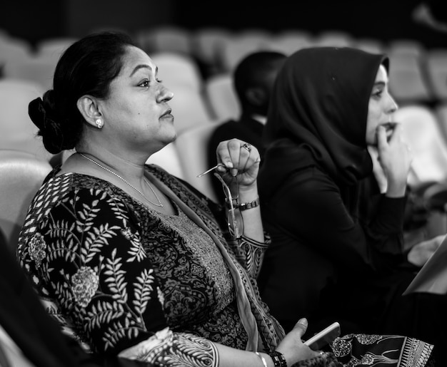 Foto grátis duas mulheres de negócios internacionais sentado em uma sala de conferência