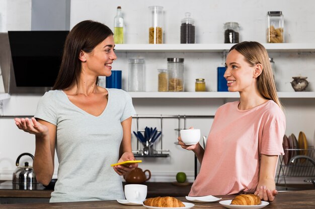 Duas mulheres em casa conversando tomando café