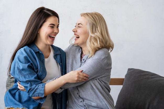 Duas mulheres felizes sorrindo e se abraçando