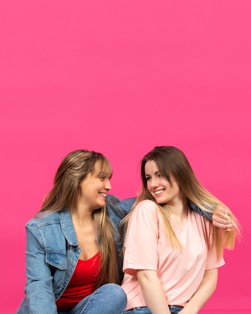 Duas mulheres jovens, sorrindo um para o outro