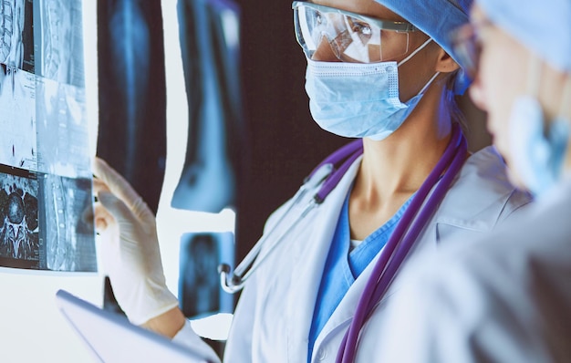 Duas mulheres médicas olhando raios-x em um hospital