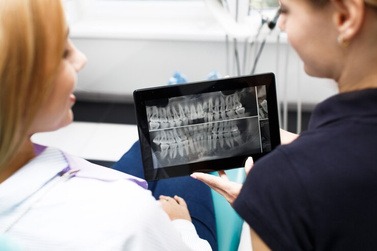 Foto grátis duas mulheres olham a imagem do dente em um tablet no escritório do dentista