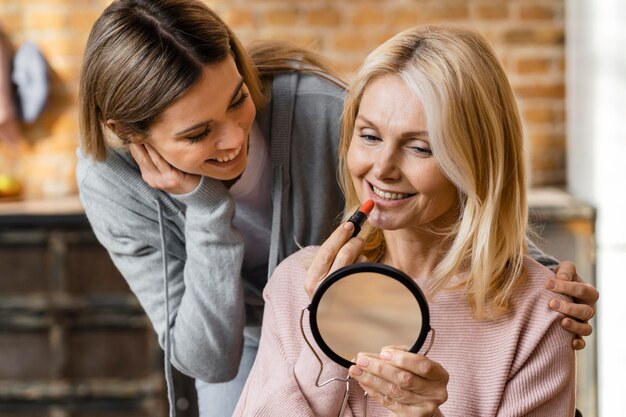 Duas mulheres se maquiando em casa