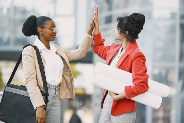 Duas mulheres trabalhando como arquitetas. Pessoas em uma construção e tomando uma decisão sobre a planta de um edifício.