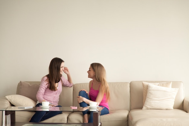 Duas namoradas jovens relaxando em casa e tendo conversa pessoal