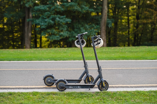 duas scooters elétricas ou e-scooter estacionadas nas laterais da estrada