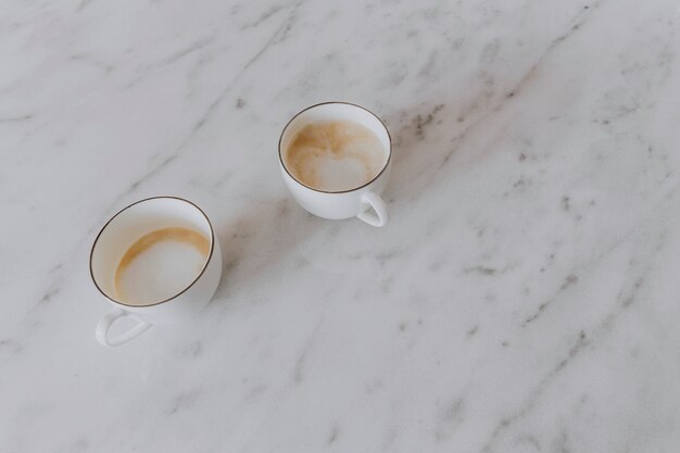 Duas xícaras de café com leite em uma mesa de mármore