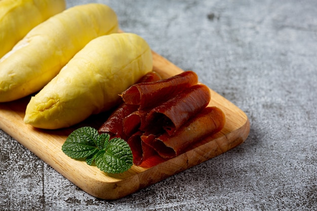 Durian e lanches na superfície escura.