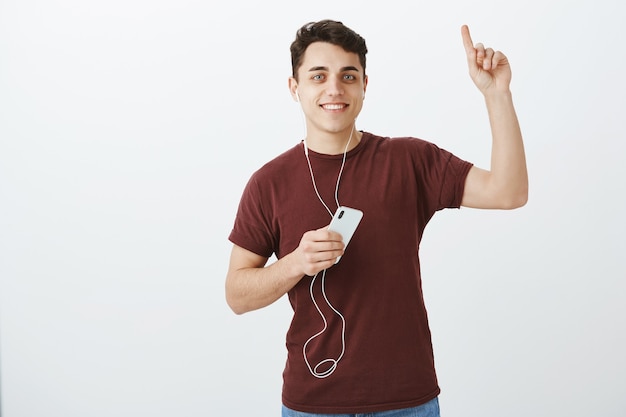 É melhor você levantar a cabeça. retrato de cliente masculino atraente positivo em fones de ouvido