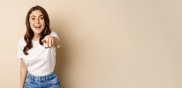 Foto grátis É você parabéns sorrindo linda mulher apontando o dedo para a câmera parabenizando elogiando você