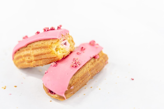 Foto grátis eclair em esmalte rosa em um fundo branco isolado