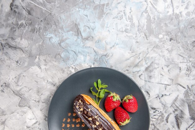 Eclairs de chocolate saborosos com morangos em bolos de frutas leves