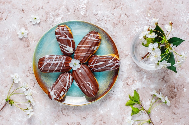 Éclairs ou profiteroles com chocolate preto e chocolate branco com creme dentro, sobremesa francesa tradicional.