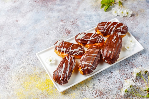 Éclairs ou profiteroles com chocolate preto e chocolate branco com creme dentro, sobremesa francesa tradicional.