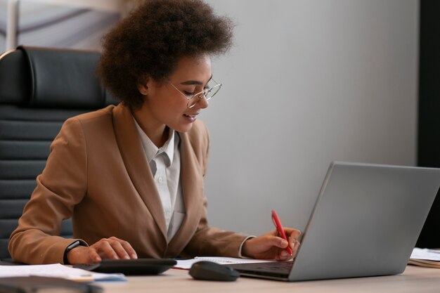 Economista feminina de tiro médio trabalhando no laptop