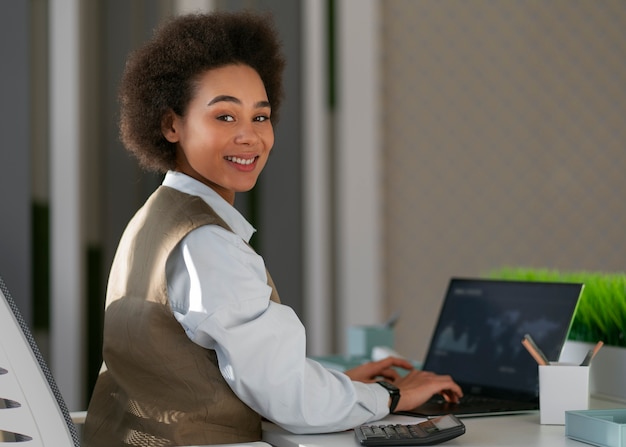 Economista feminina de tiro médio trabalhando no laptop