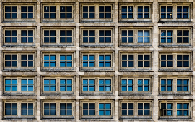 Edifício moderno com janelas de vidro testemunhando silenciosamente a vida da cidade grande