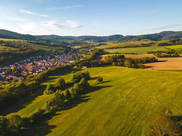 Edifícios da aldeia rodeados de relva e árvores