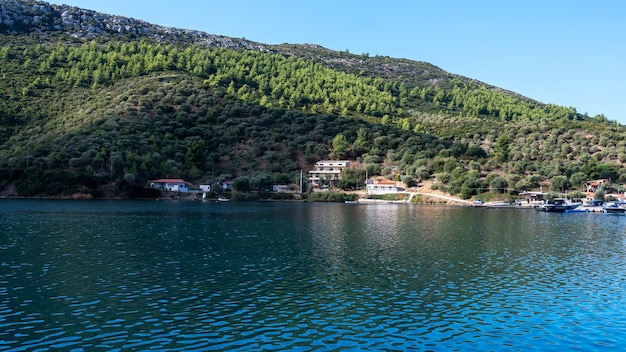 Edifícios e barcos atracados perto da água, muito verde, colinas verdes, Grécia