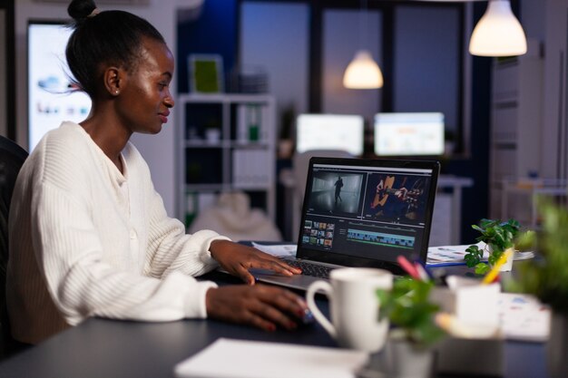 Editor de vídeo afro-americano trabalhando tarde da noite em um projeto de filme digital