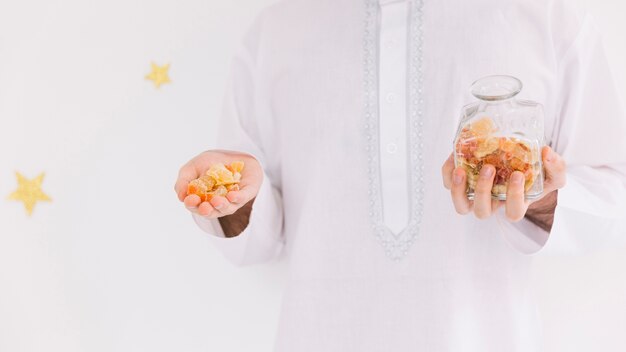 Foto grátis eid al-fitr conceito com homem apresentando pastelaria árabe