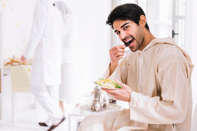 Eid al-fitr conceito com homem apresentando pastelaria árabe