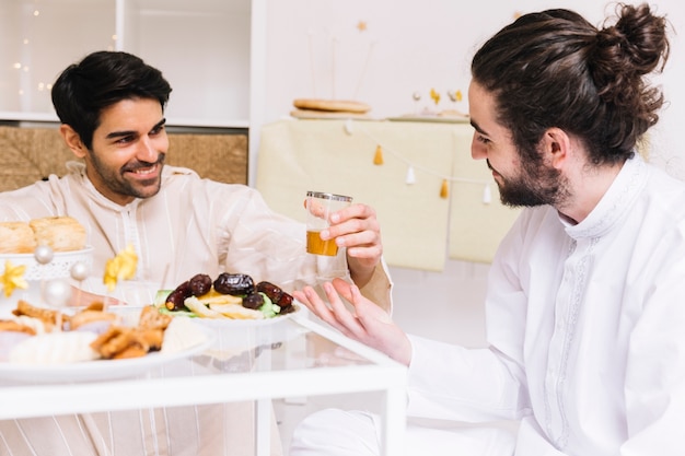 Eid al-fitr conceito com pessoas comendo na mesa