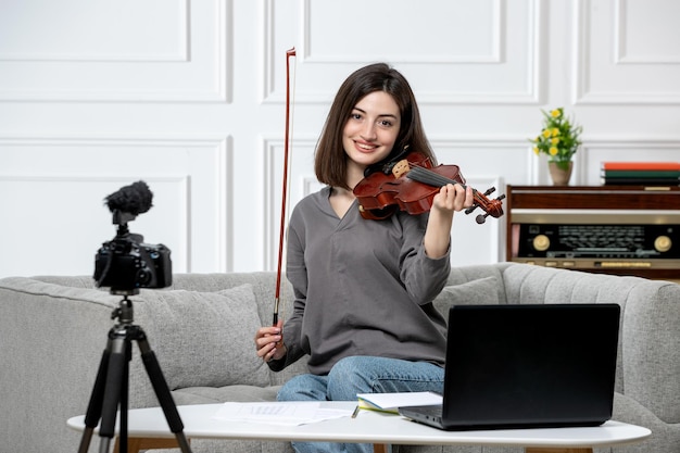 Elearning jovem linda e bonita remotamente em casa dando aulas de violino muito feliz