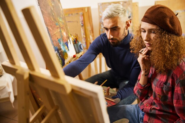 Elegante casal de artistas desenha uma pintura