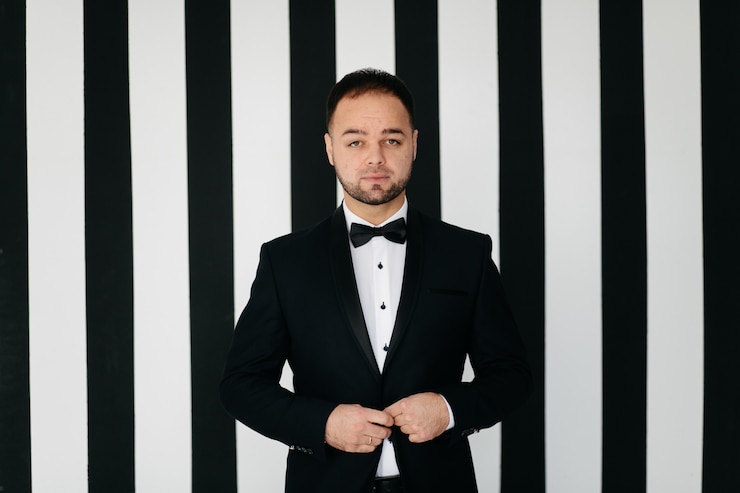 Foto grátis elegante jovem bonito em traje preto clássico. retrato da moda de estúdio.