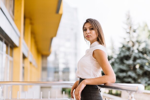 Elegante jovem empresária em pé na varanda