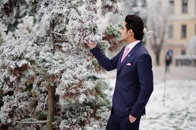 Elegante modelo de homem macho indiano de terno e gravata rosa posou no dia de inverno