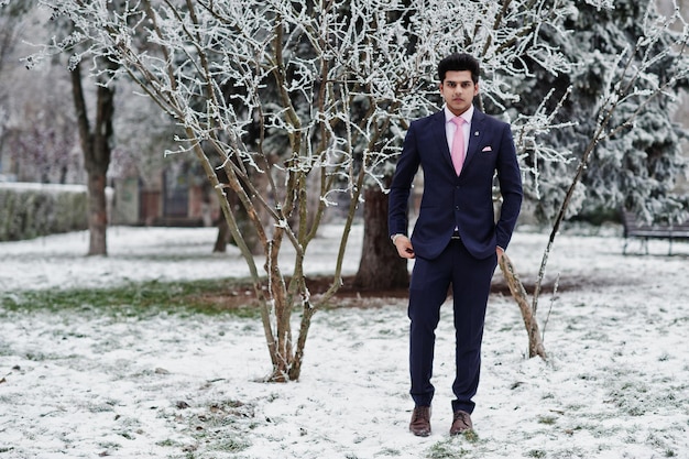 Elegante modelo de homem macho indiano de terno e gravata rosa posou no dia de inverno