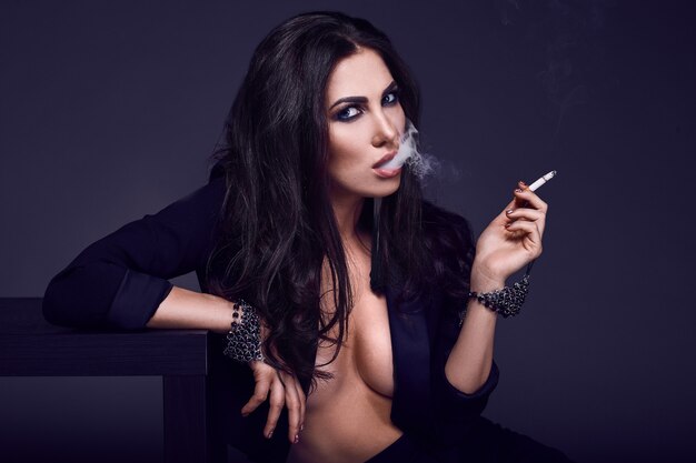 Elegante mulher morena gostosa fumando um cigarro