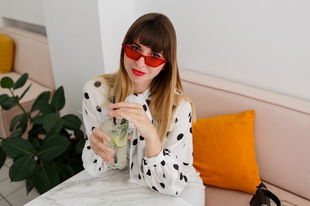 Elegante mulher sentada no café e beber cocktails