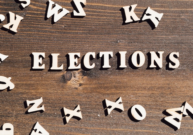 Foto grátis eleições planas leigos lettering em fundo de madeira