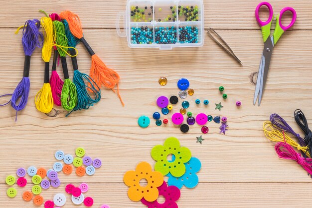Elementos decorativos coloridos com tesoura na mesa de madeira