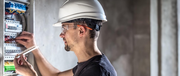 Foto grátis eletricista masculino a trabalhar numa central eléctrica com cabo de ligação eléctrica